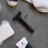 black core single blade safety razor with water droplets